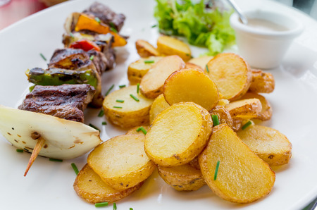 tasty grilled meat and vegetables skewers on a slate plate の写真素材