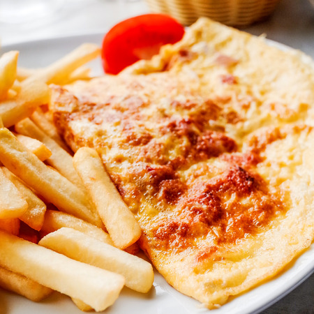 omelet with ham tomato and  french fries の写真素材