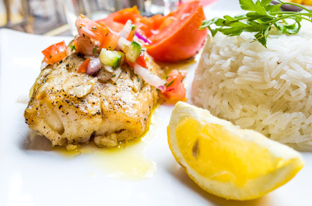 grilled salmon and lemon - french cuisine dish with tomato and salmonの写真素材