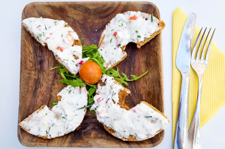 Bagel with fresh cheese and fresh lettuce on table