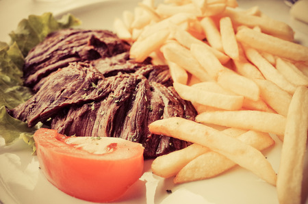 juicy steak beef meat with tomato and french fries の写真素材