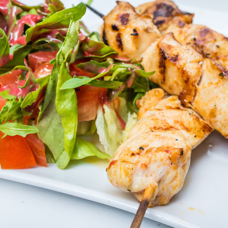 tasty kabobs with vegetables on a slate plateの写真素材