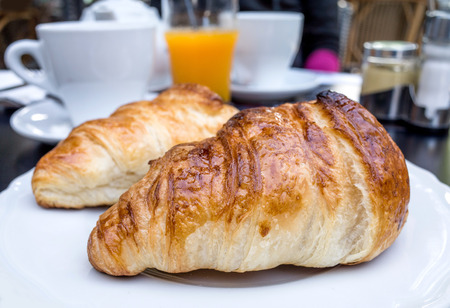 Breakfast with coffee and croissants on tableの写真素材