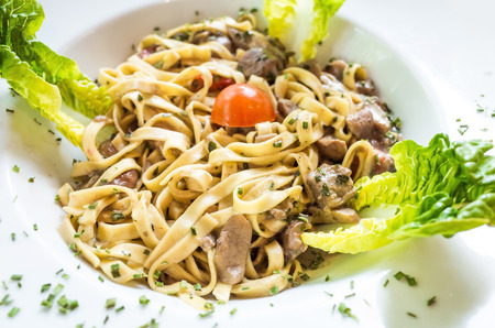 tasty pasta with roast ham on the tableの写真素材