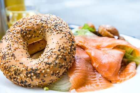 Salmon Bagel with fresh cheese and fresh lettuce on table.