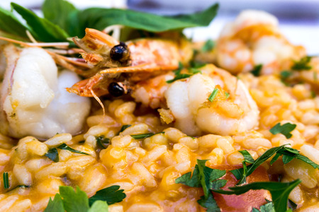 Tasty risotto with Shrimp, fresh herbs vegetables on a white plate.の写真素材