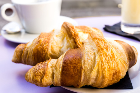 Breakfast with coffee and croissants on table