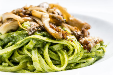 Pasta with pesto sauce and Mushrooms on a the table