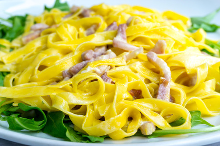 tasty pasta with roast ham on the tableの写真素材