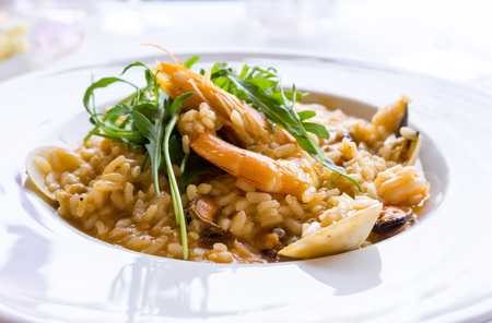Tasty risotto with Shrimp, fresh herbs vegetables on a white plateの写真素材