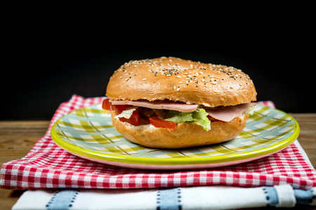Bagel with fresh cheese and fresh lettuce on tableの写真素材