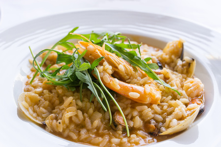 Tasty risotto with Shrimp, fresh herbs vegetables on a white plateの写真素材