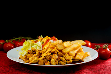 Fresh chicken with tomatoes and french friesの写真素材