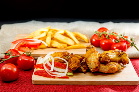 Chicken wings with sauce and golden French fries potatoesの写真素材