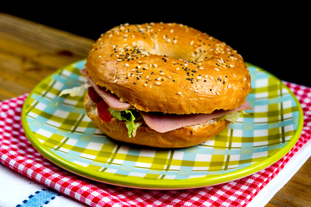 Bagel with fresh cheese and fresh lettuce on napkinの写真素材