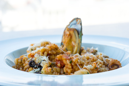 Tasty risotto with Shrimp, fresh herbs vegetables on a white plateの写真素材