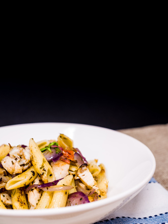 close-up of plate of pasta and chicken with lettuceの写真素材
