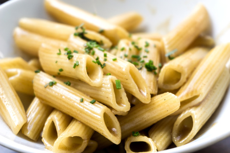 Pasta with pesto sauce and nuts on a the tableの写真素材