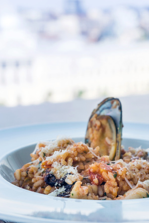 Tasty risotto with Shrimp, fresh herbs vegetables on a white plateの写真素材