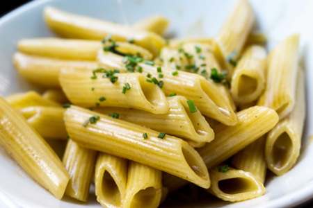 Pasta with pesto sauce and nuts on a the tableの写真素材