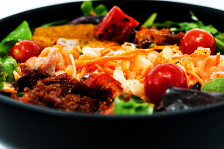 Delicious fresh salad with tomatoes, lettuce, eggplant, zucchini, cheese, parma ham and olive oil.の写真素材