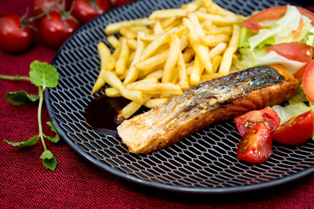 Grilled Salmon with fresh lettuce and Golden French friesの写真素材