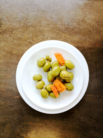 green olives in white bowl on tableの写真素材