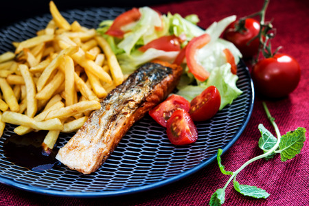 Grilled Salmon with fresh lettuce and Golden French friesの写真素材