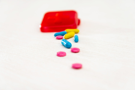 Health concept colorful medication and pills spilling out of a toppled bright bottle