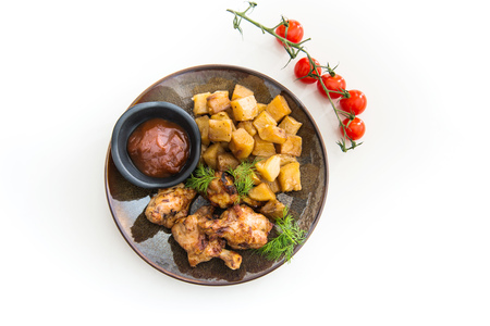 Chicken wings with sauce and golden French fries potatoesの写真素材