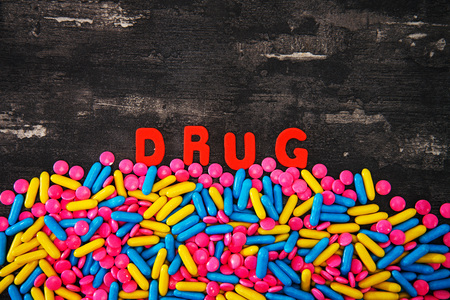 The word letters DRUGS and various medication and pills