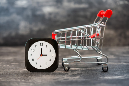 Business concept photo - shopping cart with clock