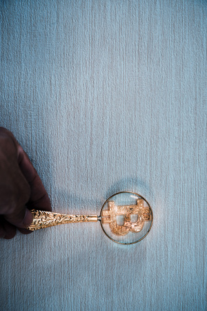 Use a magnifying glass to watch golden bitcoinの写真素材