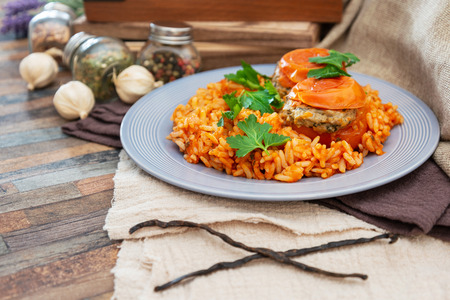 stuffed tomatoes with rice on a white plateの写真素材