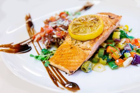 grilled salmon and lemon - french cuisine dish with tomato and salmon