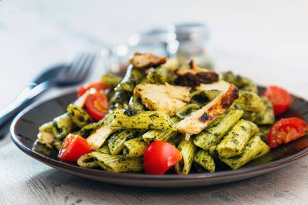 Penne cooked cereal specialty with cooked chicken fillets and a sauce made with olive oilの写真素材