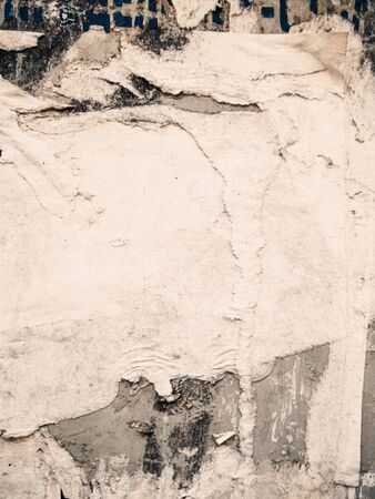 Layers of vintage posters glued and torn with time to the wall