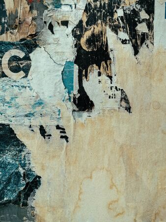 Layers of vintage posters glued and torn with time to the wall