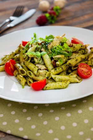 Pasta with pesto sauce and nuts on a the tableの写真素材