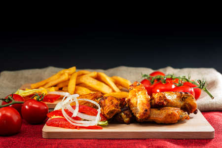 Chicken wings with sauce and golden French fries potatoesの写真素材