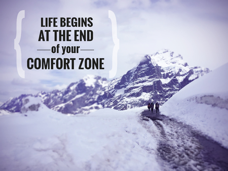 Inspirational quote "Life begins at the end of the comfort zone" on blurred snow mountain background with vintage filterの写真素材