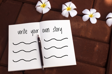 Inspirational quote "write your own story" on blurred notebook backgroundの写真素材