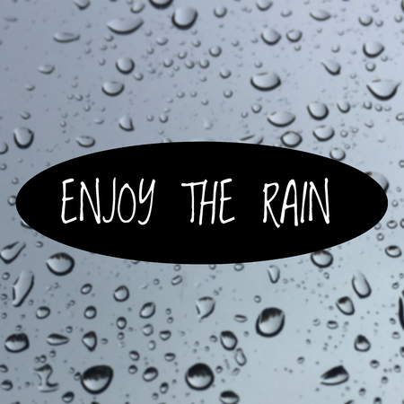 Inspirational quote "enjoy the rain" on blurred backgroundの写真素材
