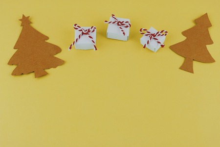 hand made paper Christmas trees and small presents on yellow background with copy space. Christmas theme.の写真素材