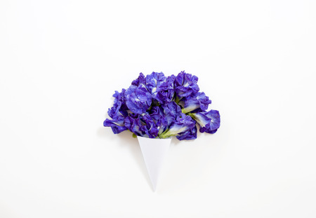 paper cone with Butterfly pea or blue pea bouquet on white background. ?at lay, top view