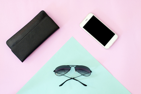 flat lay of sunglasses, wallet and smart phone on pink and blue background.
Top view.の写真素材