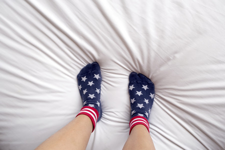 woman wearing socks stand on bed.の写真素材