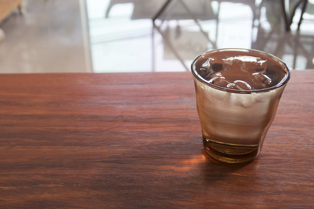 A glass of water with ice on wooden table.の写真素材
