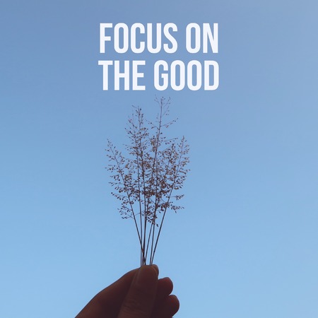 Inspiration motivational focus on the good on wild flowers with hand backgroundの写真素材