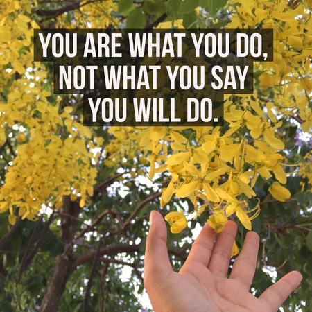 Inspirational motivational quote "You are what you do,not what you say you will do." on yellow flowers and hand background.の写真素材